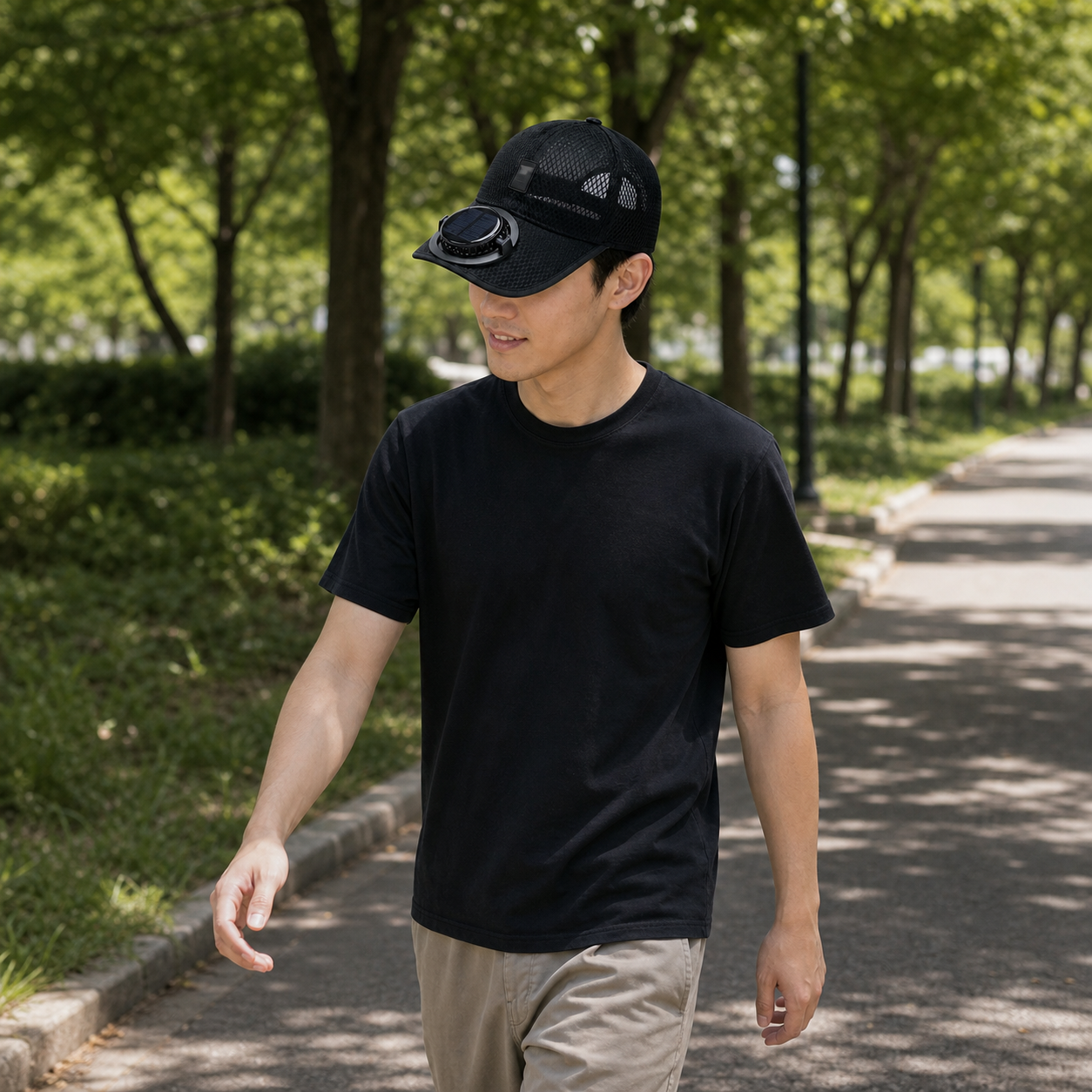 Person walking outdoors while wearing the black mesh fan cap.